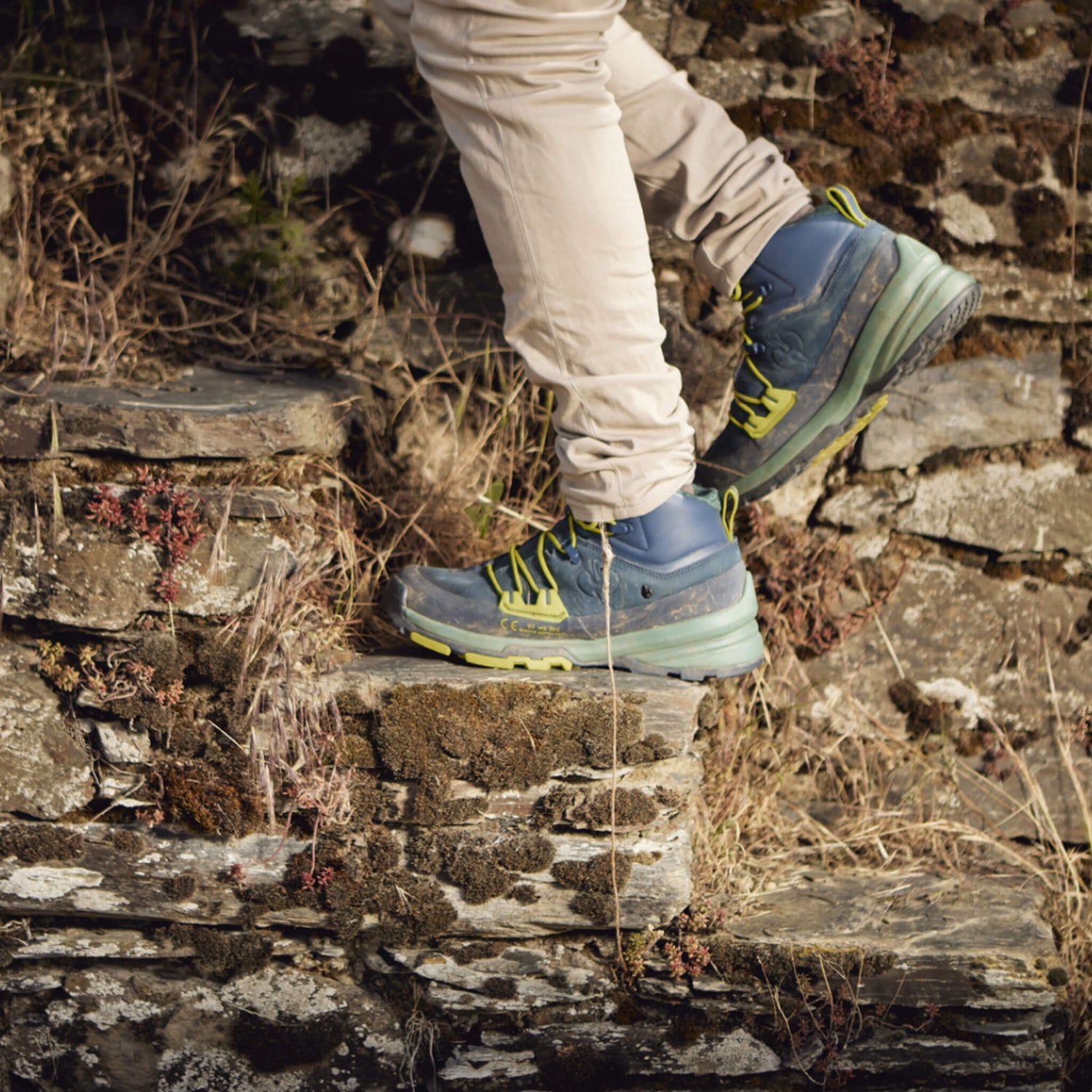 blaue Stiefel auf der Treppe einer Trockensteinmauer im Weinberg
