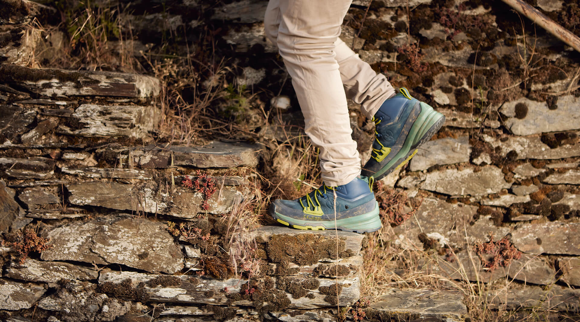 blaue Stiefel auf einer Treppe einer Trockenmauer im Weinberg